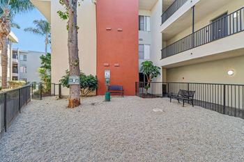 A courtyard with a red wall and a tree in the middle.